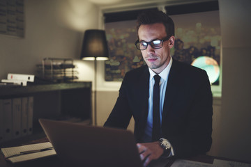 businessman typing while sitting at the laptop in the office