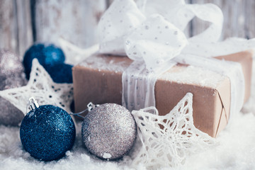 Composition with Christmas decorations and gift on white wooden background and snow