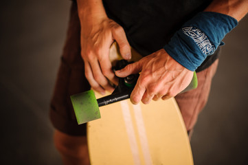 Young mans hands holding a yellow longboard