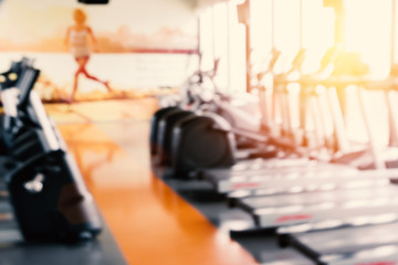 Blurry of Sports fitness workout gym with Bike and running machine or treadmill. Strength exercise and Cardio training concept. Sports center theme. Defocus sports equipment in background.