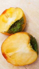 хурма на столе крупным планом. разрезанная хурма.