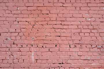 The wall is made of bricks.  It is painted with red paint.  Background.  Exterior.  Design element