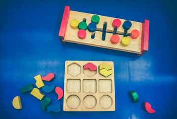 Top view of toy wooden blocks on blue background.