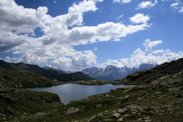 Fototapeta na wymiar paesaggio montagna lago rocce cielo azzurro