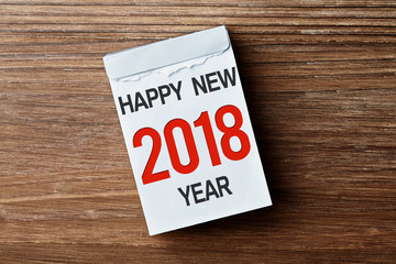 Kalender vor Holzhintergrund Happy New Year 2018