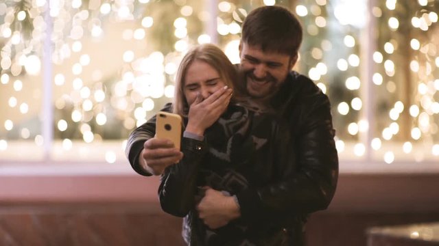 Young happy couple take selfie photos at camera on smart mobile cell phone 