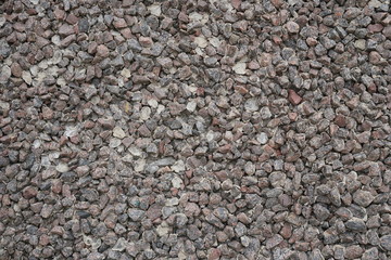 The texture of the stone.  Small fragments.  Flat view.  Dark color.  Granite.  Uniform background.