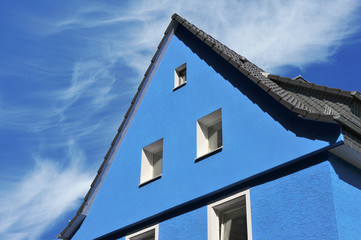 Renovierter Haus-Giebel mit blauer Front und grauem Ziegeldach