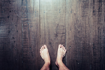 Man's feet stand on old plank wood