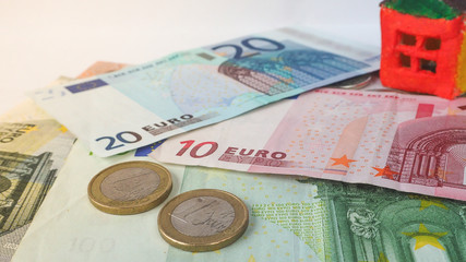 Little toy concept house on the banknotes of Euro.
