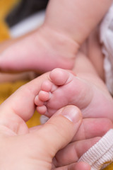 Mother giving baby foot massage against colic