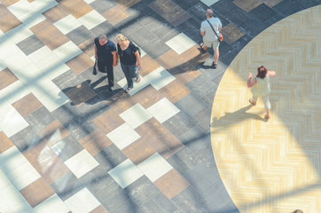 Silhouettes of Walking People in the Atrium of a Large Public Building, View from Above. Blur in Motion, Long Exposure. Abstract Background