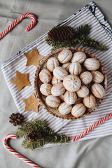 A top view of a Christmas composition with sweet crispy nuts filled with boiled condenced milk, paper stars, cones and christmas tree branches