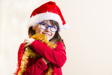 girl with santa hat playing with christmas ribbons