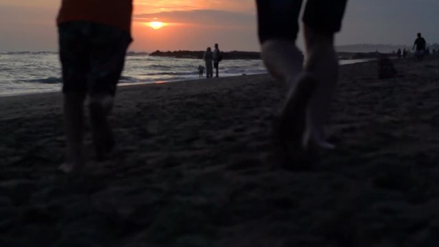 Family running on the beach during sunset, steadycam shot, slow motion shot at 240fps
