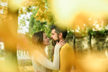 Man and woman at yellow tree leaves.