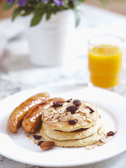 Breakfast Pancake and Sausage Top with Almond and Raisin on white plate