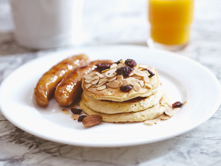 Breakfast Pancake and Sausage Top with Almond and Raisin on white plate