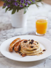 Breakfast Pancake and Sausage Top with Almond and Raisin on white plate