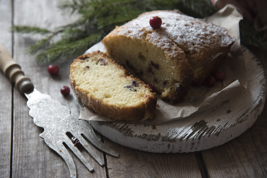 sliced cranberry cake on the wooden background and tree branch 