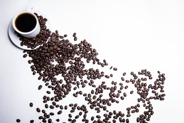 cup of coffee on a white background, scattered coffee beans, heart made of coffee beans, morning coffee at home