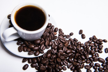 cup of coffee on a white background, scattered coffee beans, heart made of coffee beans, morning coffee at home