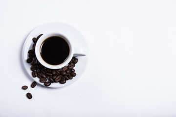 cup of coffee on a white background, scattered coffee beans, heart made of coffee beans, morning coffee at home