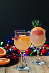 Lemonade with orange, grapefruit, red currant in wine glasses served with frut slices and christmas decoration. Celebration concept