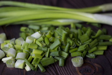 chopped onions and green onions on a wooden table