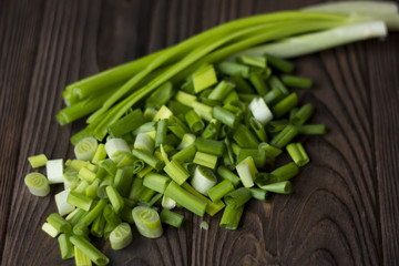 chopped onions and green onions on a wooden table
