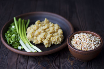 pea porridge, peas and onions in a clay pot on a wooden table