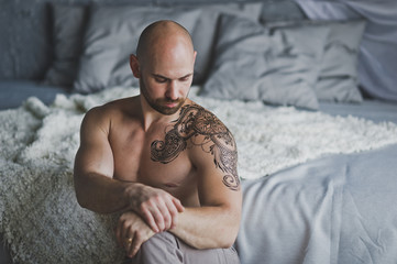 A brutal man with tattoo on shoulder and chest 1.