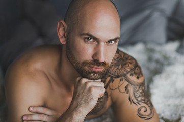 Close-up portrait of a bald brutal man with a beard 15.