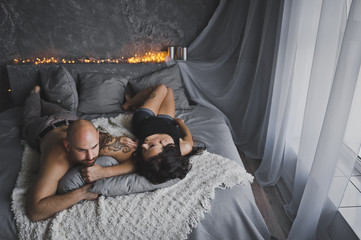 A man and a woman talking while lying on a soft bed 59.