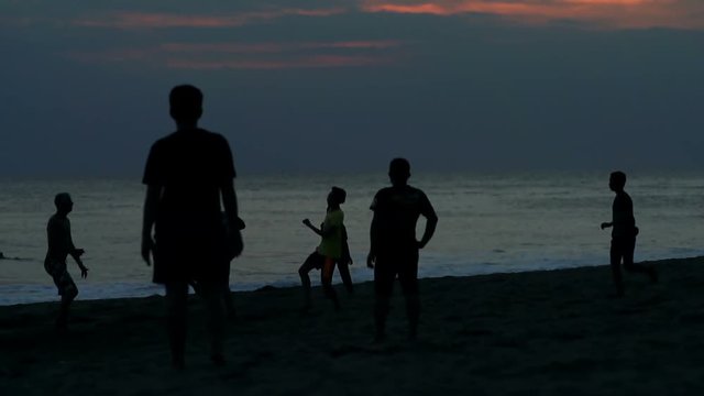 Children playing football on the beach, steadycam shot, slow motion shot at 240fps
