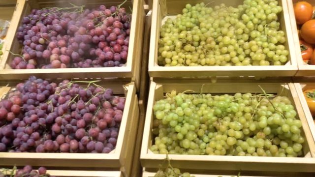 Fresh fruit assortment in rustic wooden box. Grapes, persimmons, pomegranate.