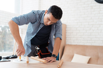 The young man tries himself to fold his coffee table and stools.