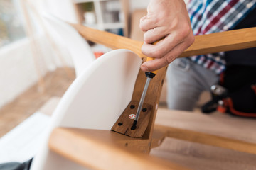 The young man tries himself to fold his coffee table and stools.