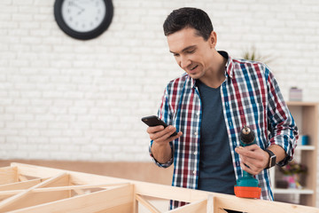 The young man tries himself to fold his bookcase.