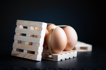 Hen's eggs tied with straps on wooden pallet.