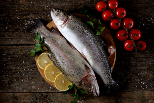 Organic raw fresh trout fish on an old wooden background. Top view. 