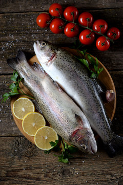 Organic raw fresh trout fish on an old wooden background. Top view. 