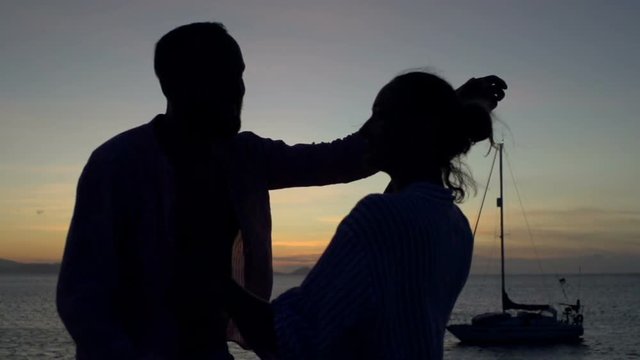 Happy couple dancing and kissing during sunset, steadycam shot, slow motion shot at 240fps
