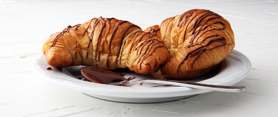Fresh homemade croissants with chocolate. Sweet bakery concept.