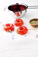 assorted donuts with sugar frosted, red glazed and sprinkles donuts.