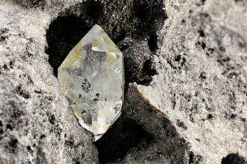 Herkimer diamond nestled in bedrock isolated on white background
