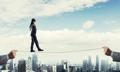 Fototapeta na wymiar Business concept of risk support and assistance with man balancing on rope
