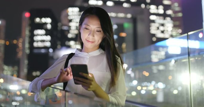 Asian businesswoman use of smart phone in city at night