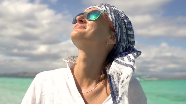 Beautiful woman wearing scarf as protection and looks happy, steadycam shot, slow motion shot at 240fps
