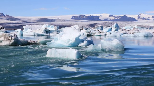 Amazing view of floating icebergs in the glacial lake Jokulsarlon on the background of clear blue sky, Iceland

